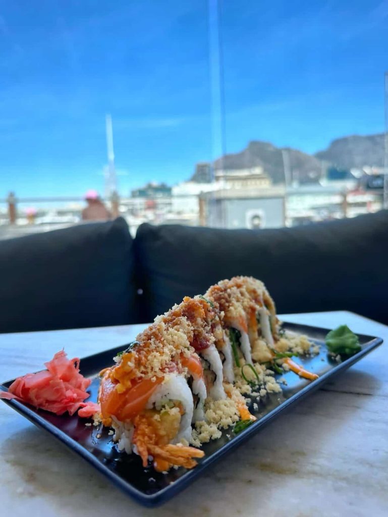 Delicious sushi roll with salmon and tempura, overlooking Cape Town cityscape