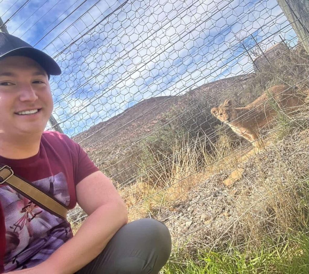 Man takes a selfie with a lion cub at a wildlife sanctuary in Cape Town