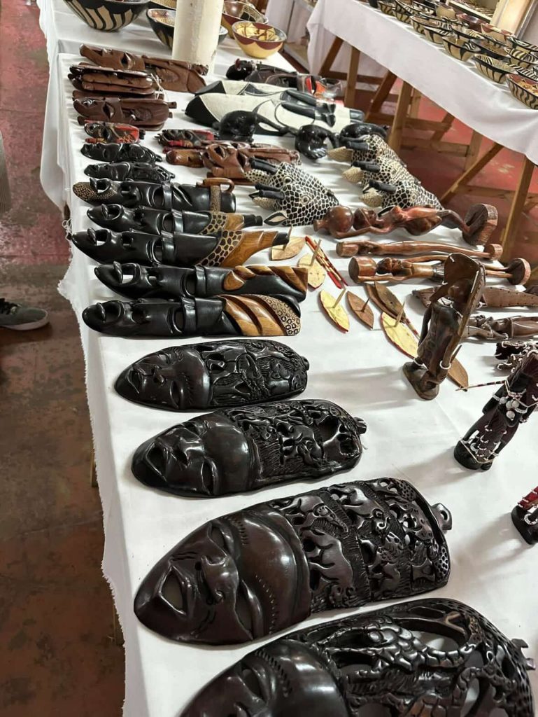 African wooden masks and carvings displayed on a table in Cape Town