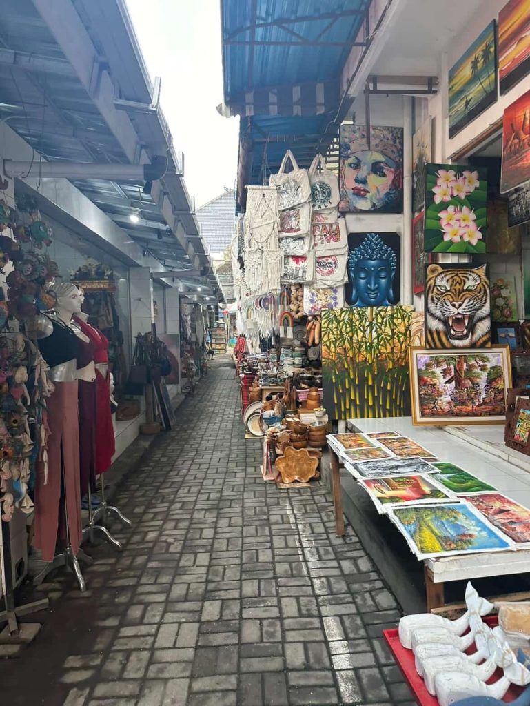 Art stalls in a Bali market with paintings and souvenirs