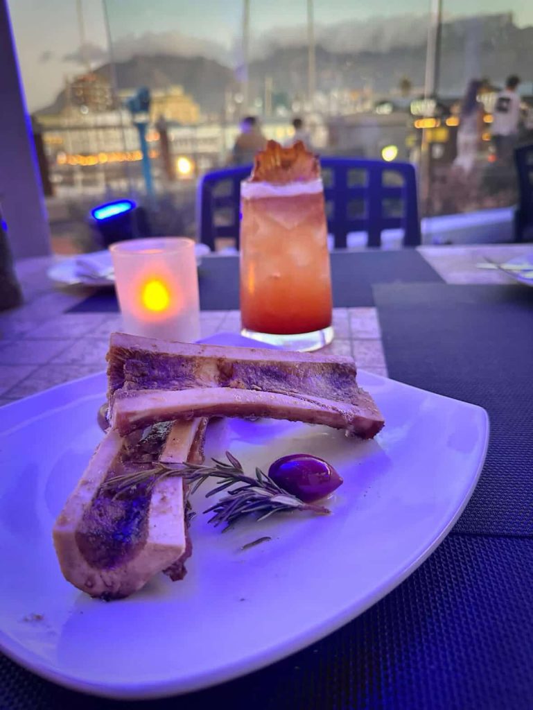Bone marrow dish with cocktail and candle at sunset in Cape Town