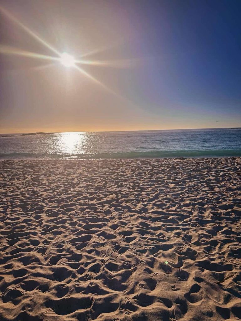 Cape Town beach at sunset with golden sun and ocean waves