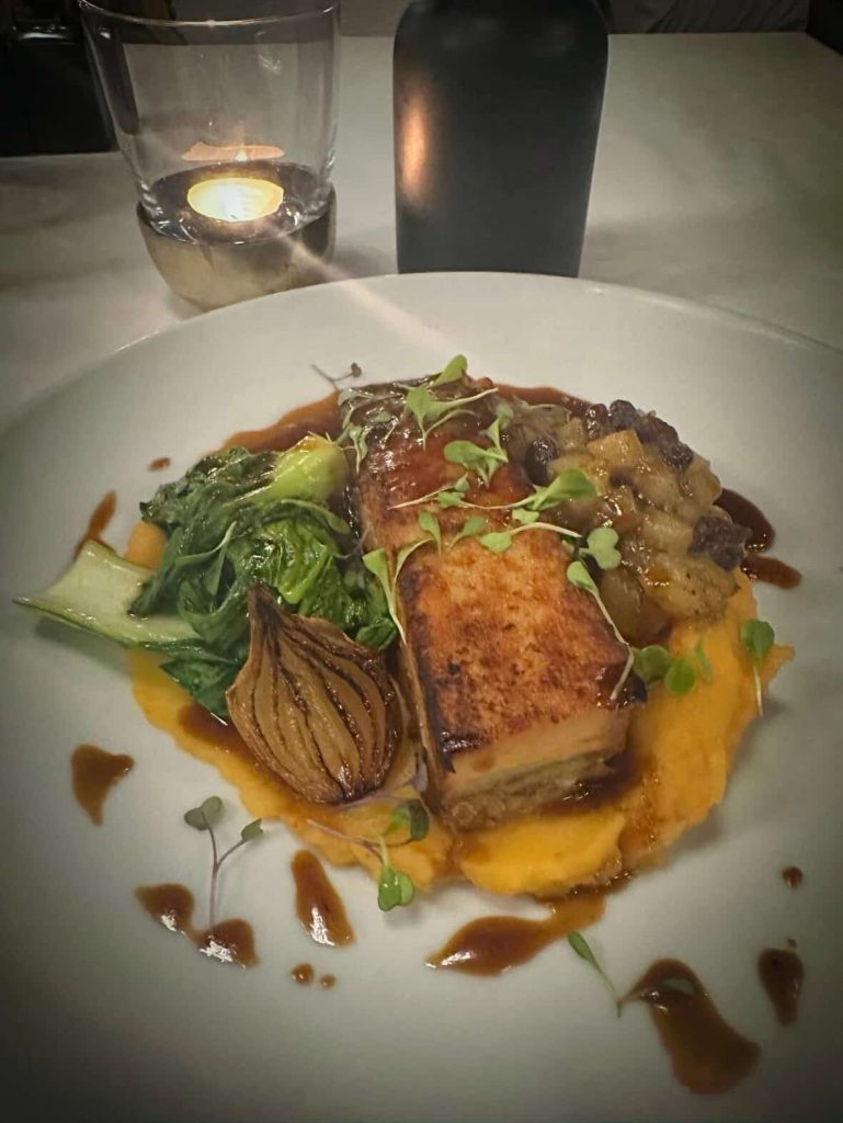 Pork belly dish with sweet potato puree, bok choy, and caramelized onion in Cape Town