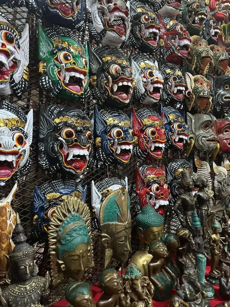 Collection of colorful Balinese masks and statues for sale