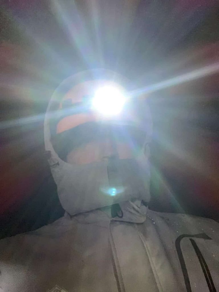 Person wearing a headlamp shining brightly, ready for adventure in Reykjavik.