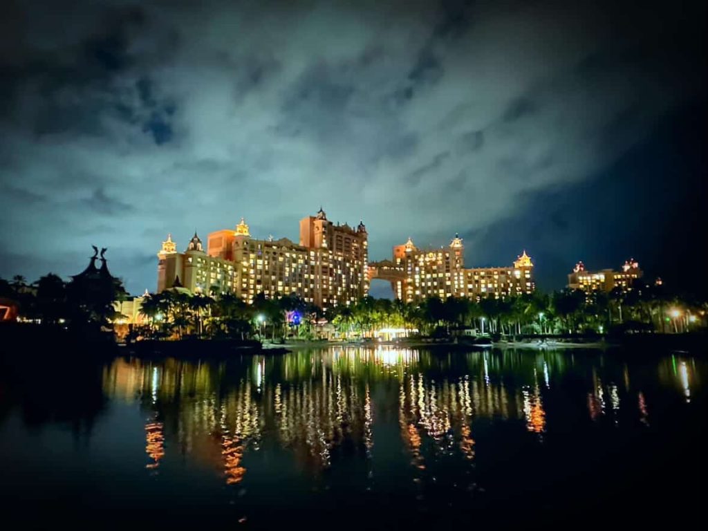 Atlantis Paradise Island resort in Nassau at night, reflecting on the water.