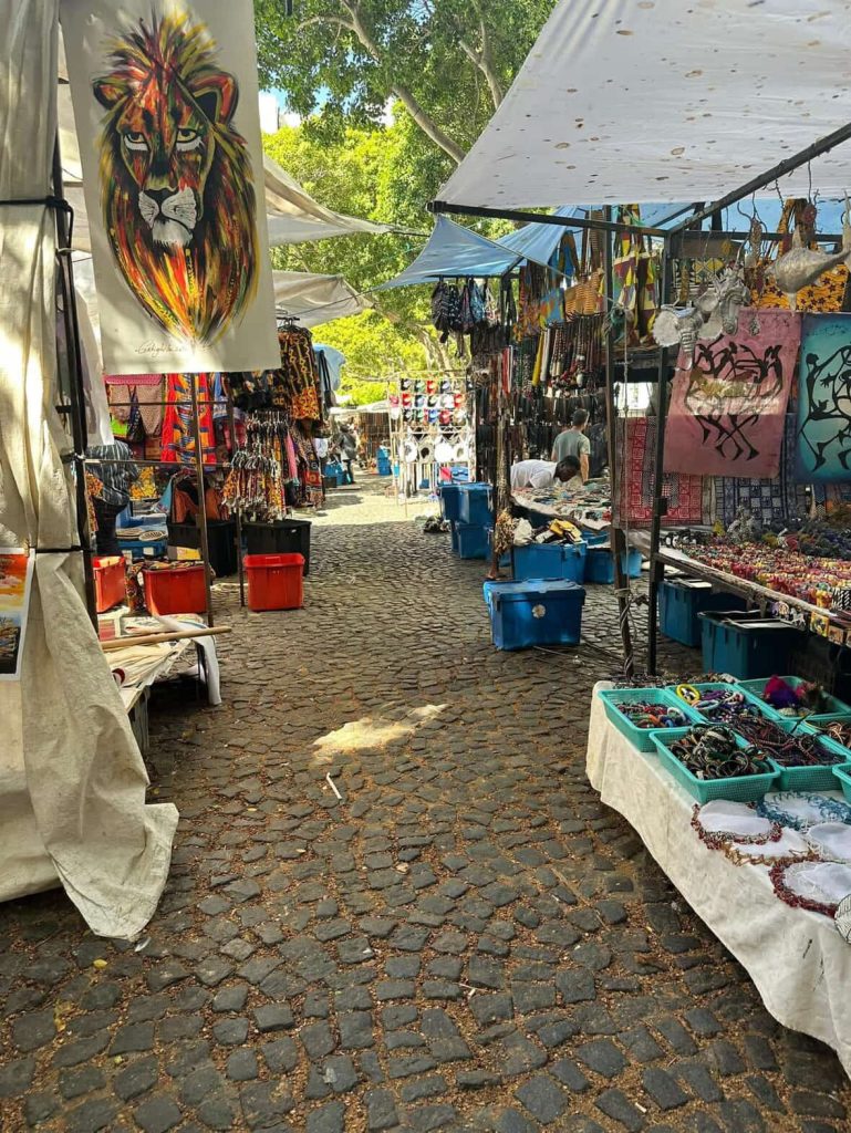 Colorful outdoor market stalls in Cape Town selling African crafts and jewelry.