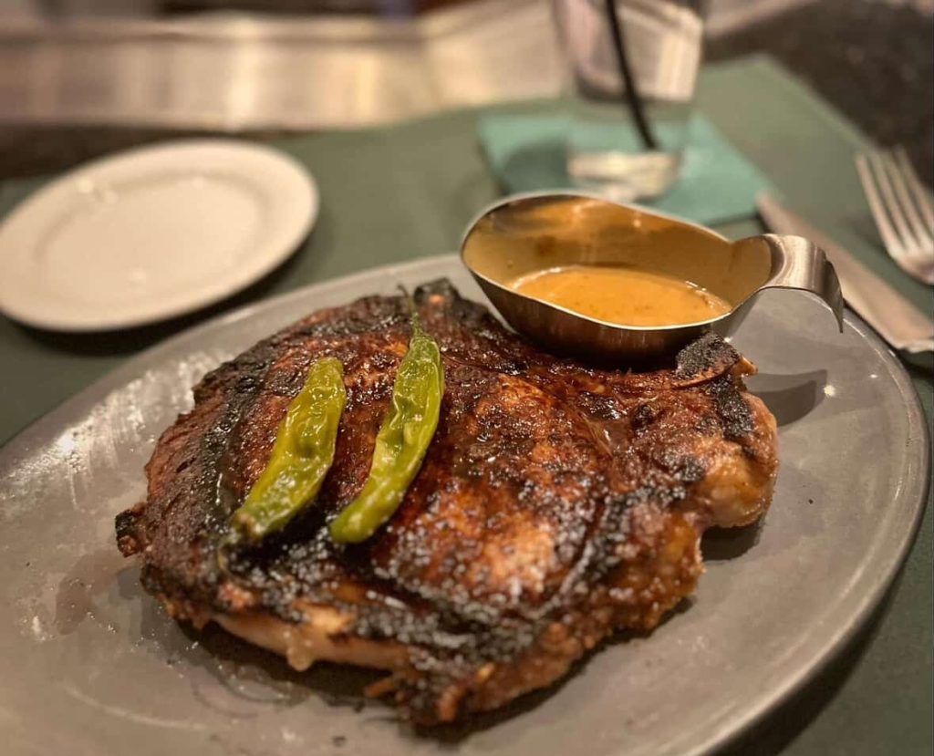 Steak with peppers and sauce on a gray plate in Las Vegas.