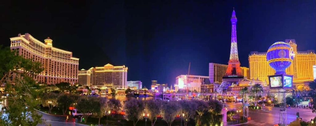 Las Vegas Strip at night, featuring the Bellagio and Paris Hotel with Eiffel Tower illuminated.