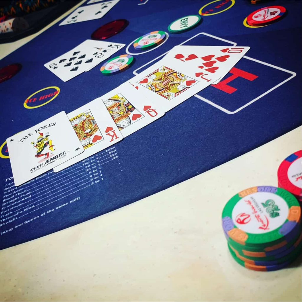Casino card game layout with a Joker, King, and Queen. Chips and payout odds are visible.
