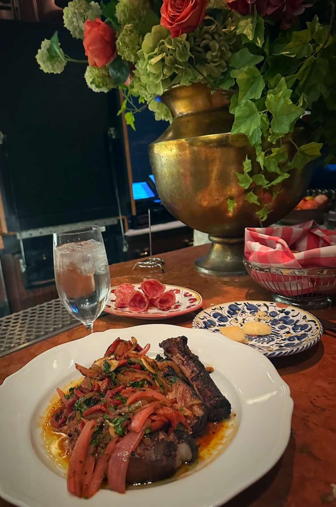 Steak dinner in Las Vegas with charcuterie, water, and floral centerpiece.
