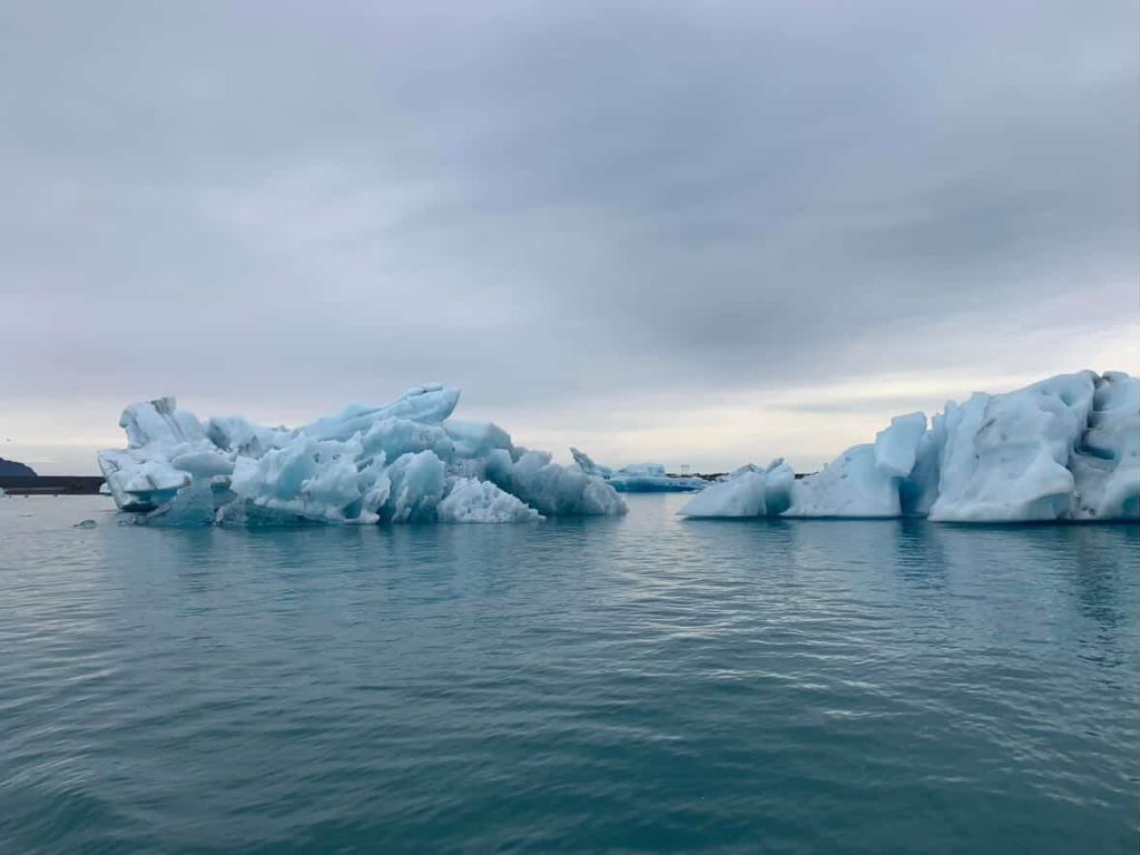 Icebergs floating in Jokulsarlon glacier lagoon, Iceland under a cloudy sky.