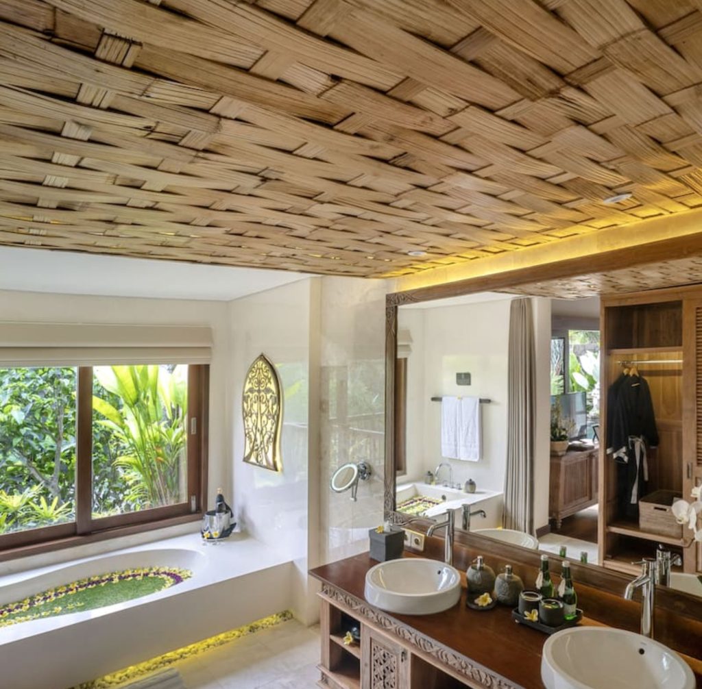 Luxury Bali bathroom with woven bamboo ceiling, large soaking tub, and double vanity.