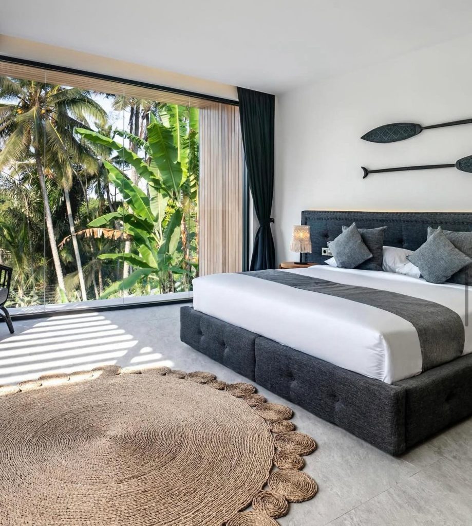 Luxury Bali bedroom with large window overlooking lush tropical jungle