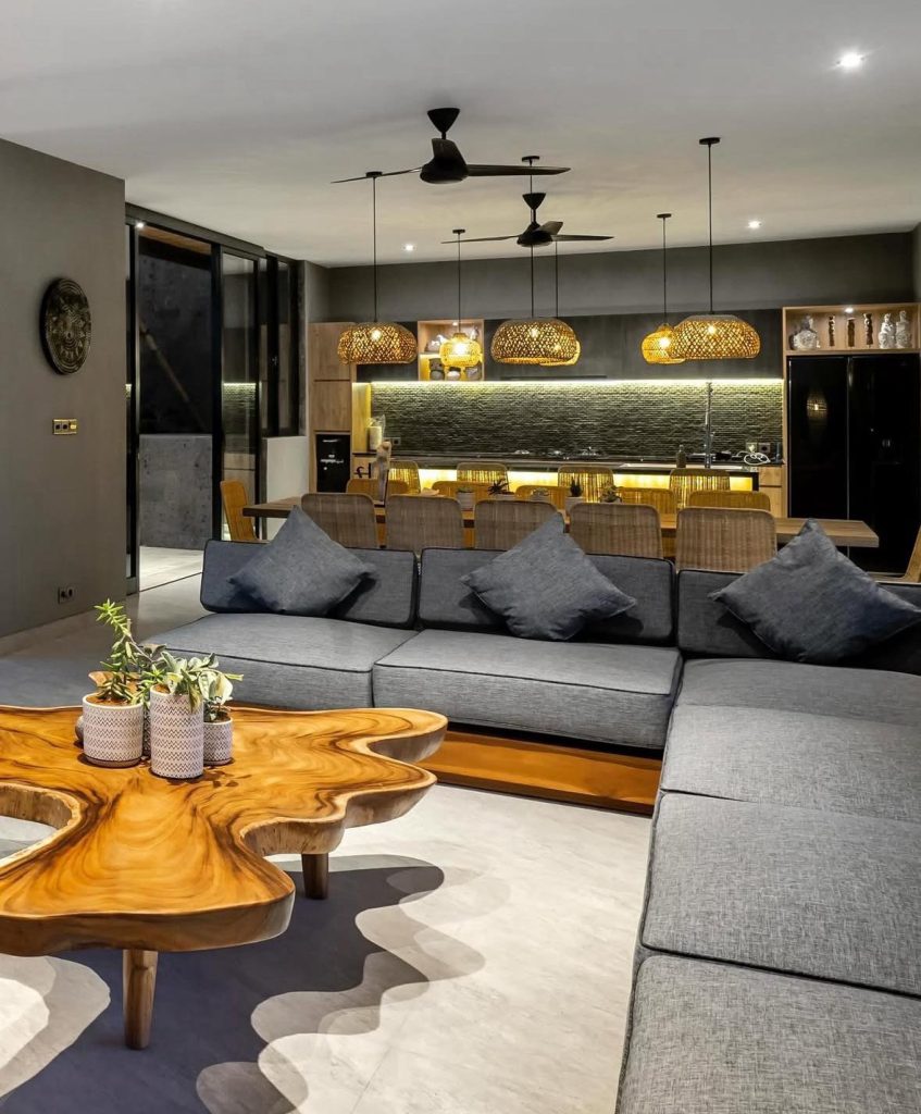 Modern Bali living room with gray sectional sofa and unique wood coffee table.