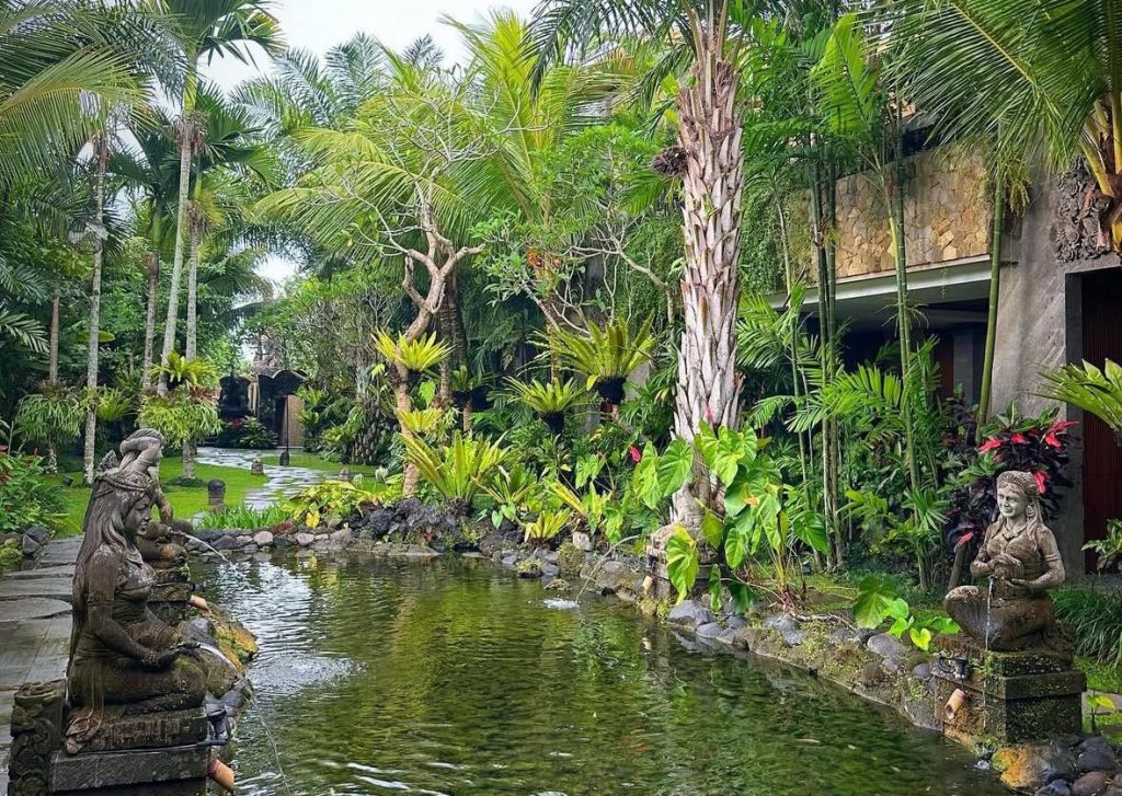 Serene Bali garden with stone statues and a tranquil pond