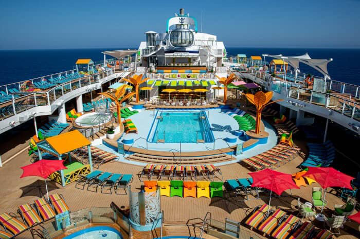 Cruise ship pool deck with colorful lounge chairs and the North Star observation pod.