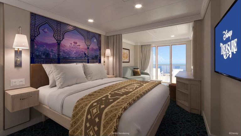 Disney Treasure cruise stateroom with a king bed, balcony, and Aladdin-themed decor.