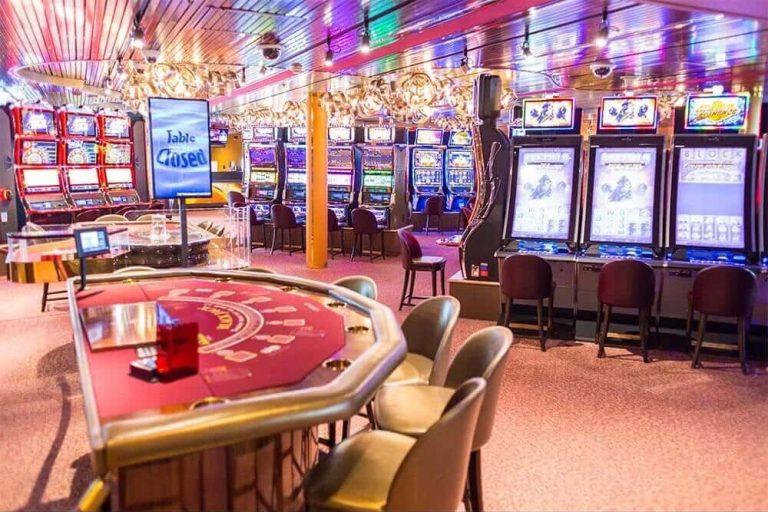 Cruise ship casino with slot machines and a closed blackjack table. Table Closed sign visible.