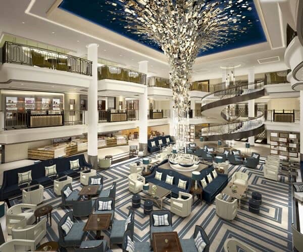 Cruise ship atrium with grand chandelier and spiral staircase.