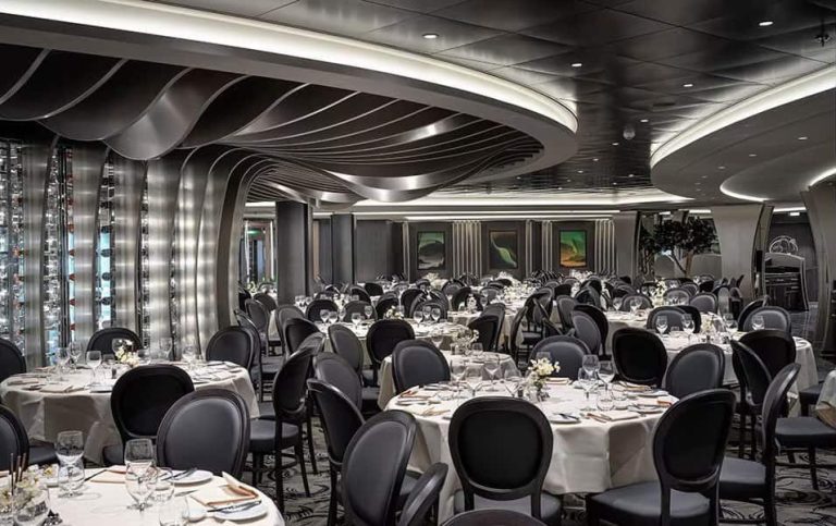 Elegant cruise ship dining room with set tables and modern decor.
