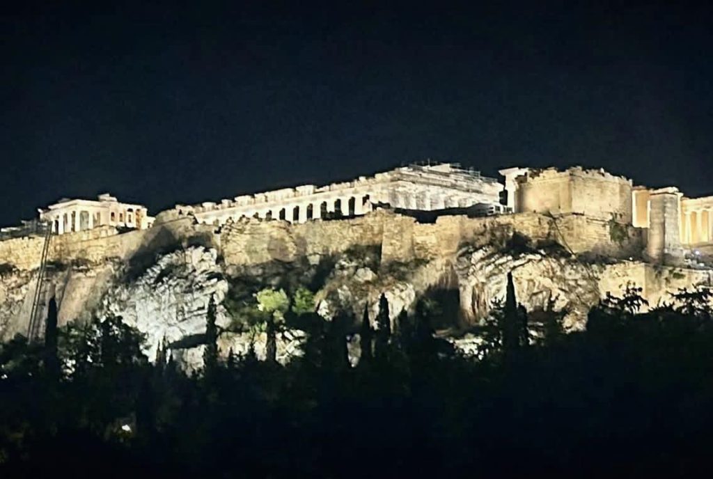 The Acropolis of Athens illuminated at night, showcasing ancient Greek architecture.