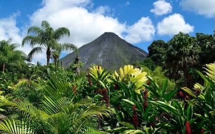Arenal Volcano in Costa Rica surrounded by lush tropical rainforest and exotic plants.