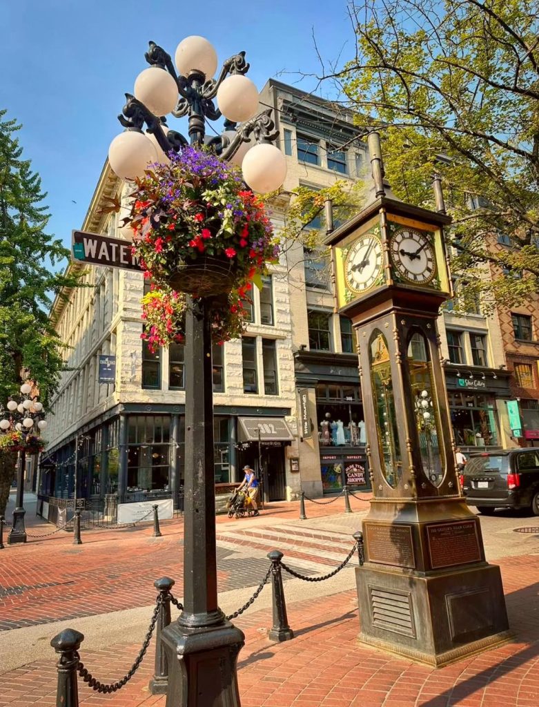 Gastown Vancouver street scene with clock tower and flower-laden lamppost.