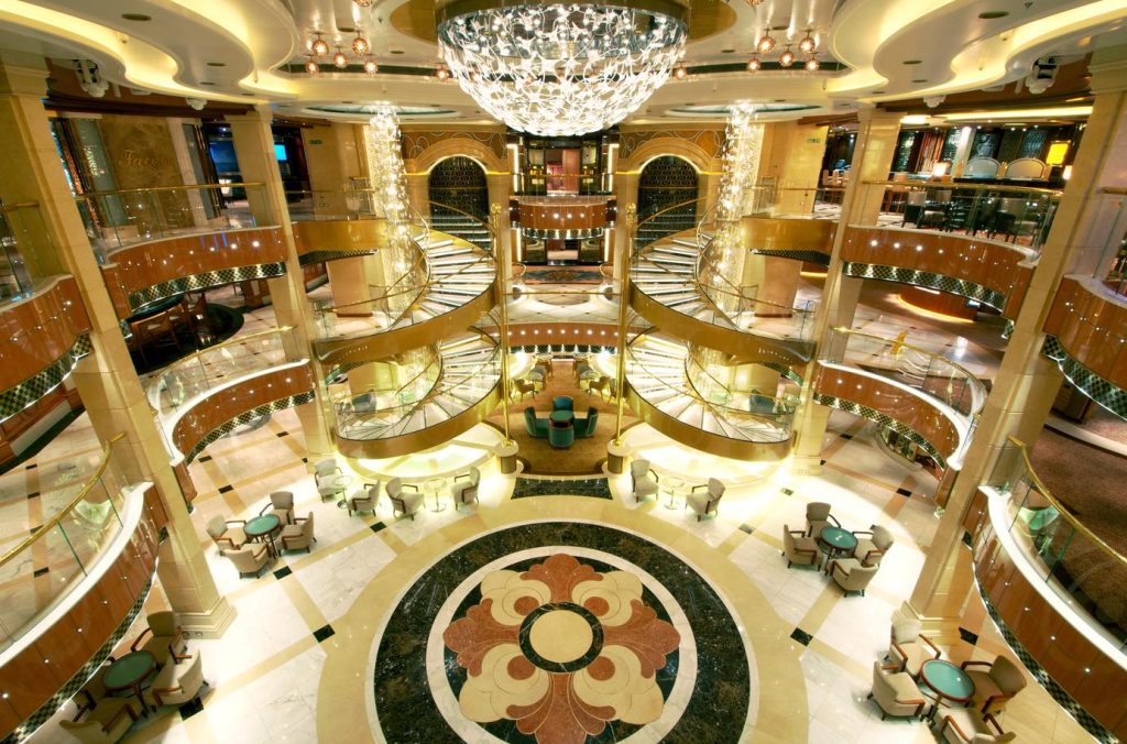 Grand atrium with spiral staircases, chandeliers, and seating areas