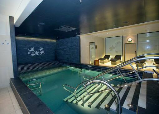 Indoor swimming pool with blue walls and white tiled floor