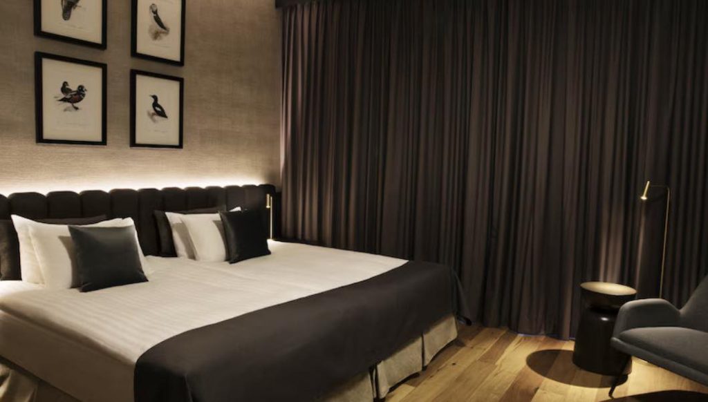Modern bedroom with bed, pillows, and artwork on wall