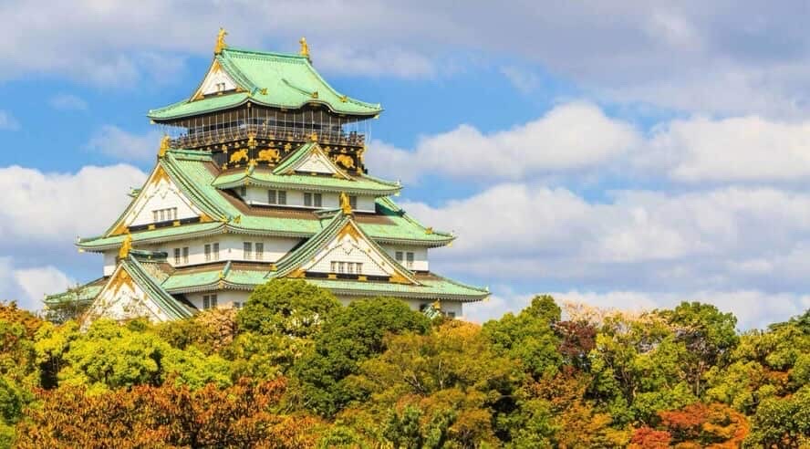 Osaka Castle in Japan, a historic landmark surrounded by autumn foliage.